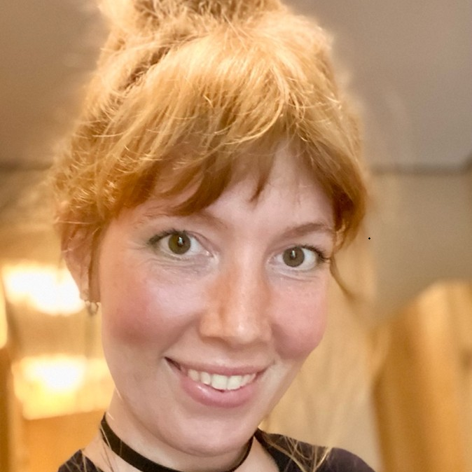 Autorinnenfoto von Ronja Rössler. Ronja hat rotblondes Haar, einen Pony und lächelt.